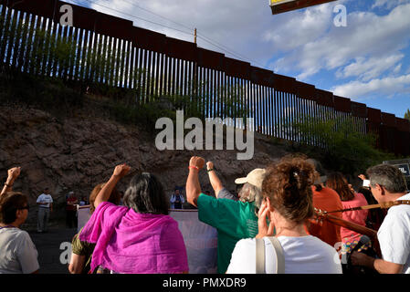 I manifestanti in Nogales, Sonora, Messico, sollevare i loro pugni al muro di confine a Nogales, in Arizona, Stati Uniti d'America, durante una manifestazione di protesta della ripresa di un adolescente in me Foto Stock