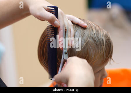 Taglio di capelli di un ragazzino in bambini parrucchiere Foto Stock