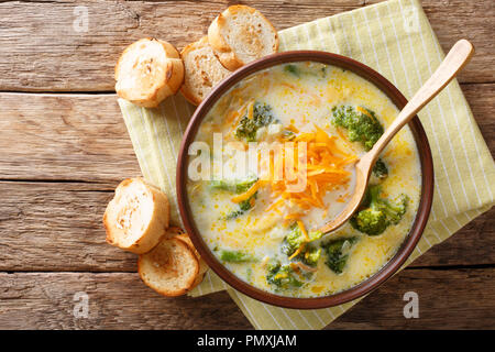 Pranzo sano di broccoli zuppa di formaggio in una ciotola con toast vicino sul tavolo. Parte superiore orizzontale vista da sopra Foto Stock