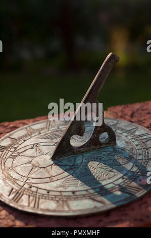 Avvicinando 5pm per andare a casa come registrato su un ottone meridiana spiovente rivestito in patina con gnomone ombra sul quadrante e regolazione del sole Foto Stock