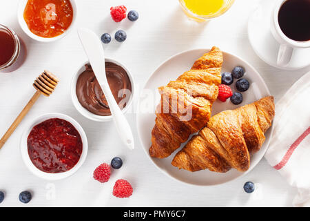 La prima colazione continentale con croissant, marmellata, cioccolata spalmabile e caffè. Vista superiore Foto Stock