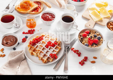 La prima colazione con muesli dadi berry, waffle, toast, marmellata, cioccolata spalmabile e caffè Foto Stock