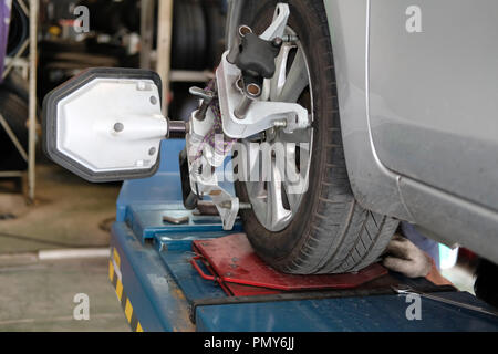 Pneumatico auto serrati con riflettore allineatore attrezzo di regolazione per controllare l'allineamento delle ruote in garage auto Servizio di riparazione Foto Stock