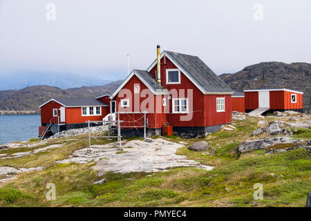 Tipico villaggio inuit case di legno dipinte di rosso sulla riva del mare. Itilleq, Qeqqata, Groenlandia. Su una piccola isola a 2 km a nord del circolo polare artico Foto Stock