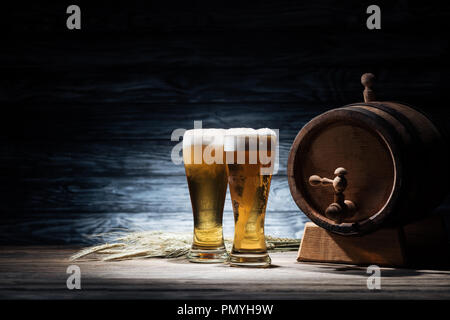 Due bicchieri di birra di frumento e spikelets barile di birra sul tavolo di legno, oktoberfest concept Foto Stock