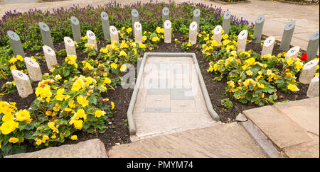 Liverpool Wirral Port Sunlight Village gardens park Analemmatic meridiana orizzontale giubileo di Diamante Meridiana 2012 fiori gialli gnomone persona ombra Foto Stock