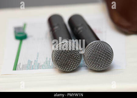 Due nero karaoke microfoni stand su un tavolo bianco Foto Stock