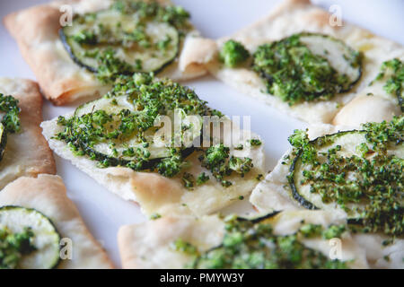 Cibo sano, pizze o focacce w/ il mais dolce e zucchine. Retroilluminazione, sano e vegano vegetariano. Fotografia di cibo. Tabella, le erbe aromatiche e i broccoli. Foto Stock