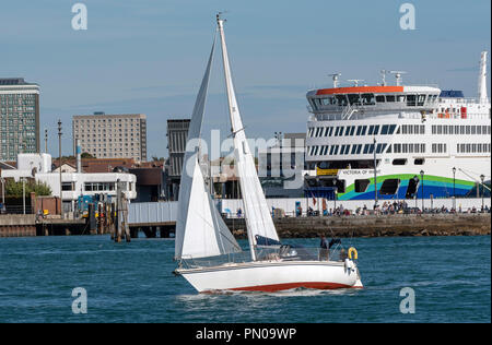 Yacht passando il Wightlink ferry terminal sul porto di Portsmouth nel Regno Unito. Sulla banchina del nuovo traghetto roro, Victoria di Wight Foto Stock