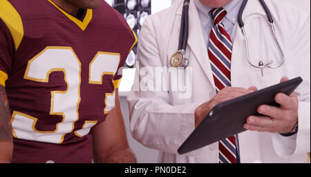 Close-up di medico guardando il computer tablet con sport atleta. Foto Stock