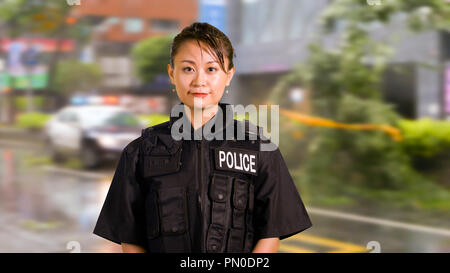 Asian donna americana ufficiale di polizia a scena del crimine Foto Stock