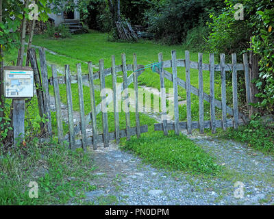 Barriera di token di vecchi ruvido legno argentato garden gate fissata con lo spago blu in Ariège, Pyrénées, Francia Foto Stock