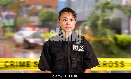 Asian donna americana ufficiale di polizia a scena del crimine Foto Stock