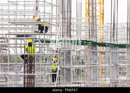 Costruzione asiatica dei lavoratori sui ponteggi di edificio sito in costruzione nella città. espansione urbana nella città capitale di asia sono in rapida crescita Foto Stock