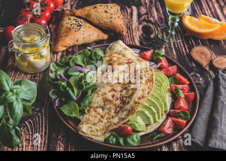 Omelette con avocado, pomodoro, mozzarella, succo di arancia, samsa. Cibo sano Foto Stock