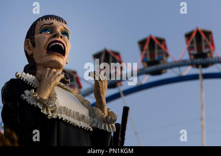 La figura da un Haunted House ride di fronte alla ruota panoramica Ferris a Monaco di Baviera Oktoberfest in Germania Foto Stock
