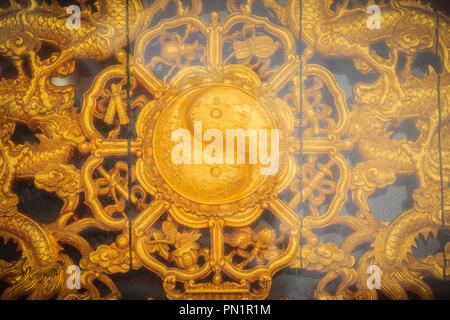 Golden simbolo di yin-yang sul muro del tempio Cinese in Thailandia. Foto Stock