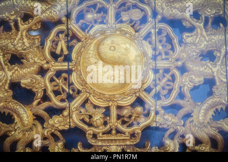 Golden simbolo di yin-yang sul muro del tempio Cinese in Thailandia. Foto Stock