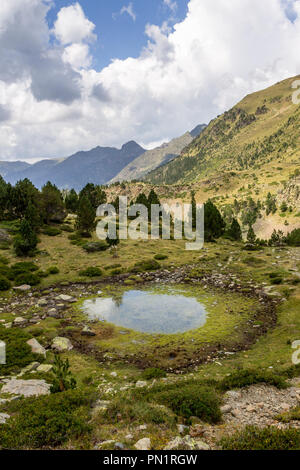 Un piccolo stagno su una collina tra la gamma della montagna. Foto Stock