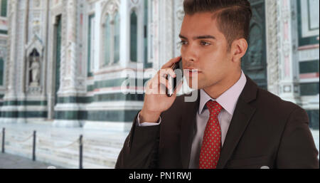 Latino imprenditore a parlare con il cliente sul cellulare Duomo di Firenze in FIRENZE Foto Stock