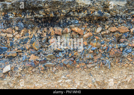 Lo strato di asfalto con delle rocce e del suolo dopo la frana. Foto Stock