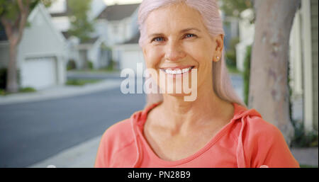 Una vecchia donna nel suo quartiere suburbano Foto Stock