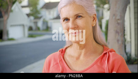 Una vecchia donna nel suo quartiere suburbano Foto Stock