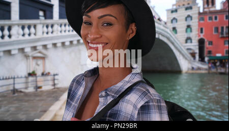 Bella donna afro-americana vicino al Ponte di Rialto di Venezia pone felicemente Foto Stock