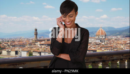 Giovane femmina nero parlando al telefono intelligente a Firenze Italia Foto Stock