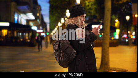 Confuso bionda turista femminile a Parigi la navigazione di posizione a Champs Elysees Foto Stock