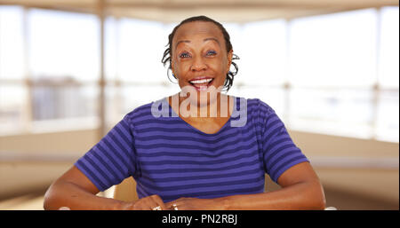 Un casualmente vestito nero imprenditrice sorridente in telecamera Foto Stock