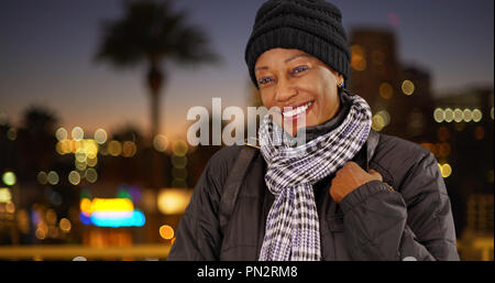 Un vecchio nero donna in abiti caldi in centro a notte Foto Stock