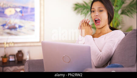 Giovane donna è scioccata guardando il suo team perdere la partita sul suo computer Foto Stock