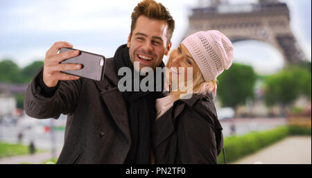 Attrazione turistica giovane a Parigi prendendo un selfie vicino alla Torre Eiffel Foto Stock