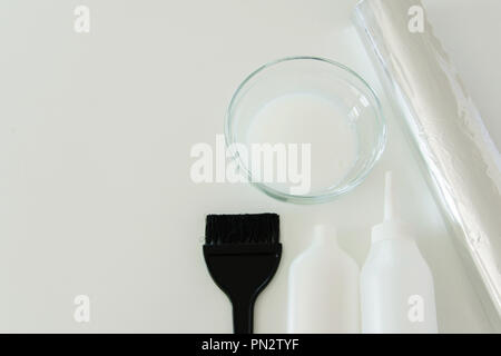 Tintura per capelli strumenti su sfondo bianco, spazio per il testo Foto Stock