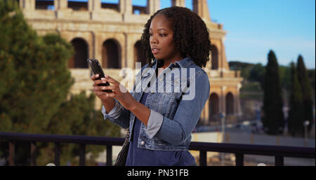Bella donna nera il viaggio a Roma Mappa controllo app sul telefono cellulare Foto Stock