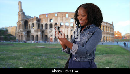 Carino donna nera in vacanza a Roma ride al testo divertente da ragazzo Foto Stock