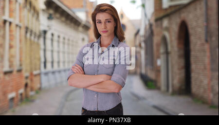 Femmina bianca che pongono gravemente in vuote street in Bruges Belgio Foto Stock