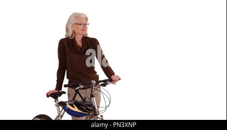 Sorridente senior femminili in posa in sicurezza con bicicletta su bianco spazio di copia Foto Stock