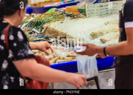 La donna non identificato al mercato del pesce è di acquistare la misura extra large di gigante malese (gamberi MACROBRACHIUM ROSENBERGII) noto anche come il gigante r Foto Stock