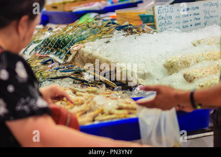 La donna non identificato al mercato del pesce è di acquistare la misura extra large di gigante malese (gamberi MACROBRACHIUM ROSENBERGII) noto anche come il gigante r Foto Stock