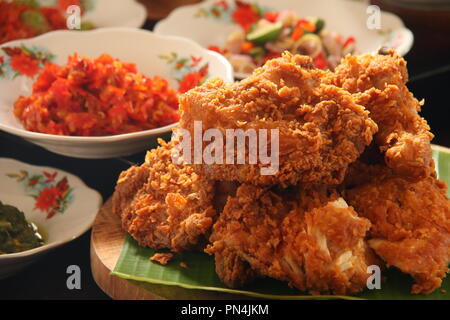 Ayam Geprek. Fusione di cibo di strada del sud del pollo fritto con tradizionale condimento piccante da indonesiano cucine regionali. Foto Stock
