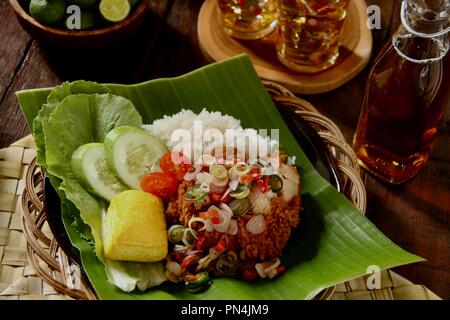 Ayam Geprek Sambal Matah. Fusion street food piatto di pollo fritto e rabboccato con sambal Matah, il peperoncino Balinese - salsa alla citronella. Foto Stock