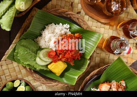 Ayam Geprek Balado. Fusion street food piatto di pollo fritto e rabboccato con sambal Lado o Sambal Oelek, il tradizionale rosso pasta di peperoncino. Foto Stock