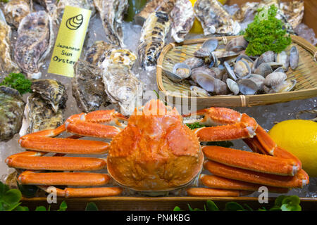 Rosso fresco grancevole, giapponese sun ostriche e altri frutti di mare display sul ghiaccio in stallo presso il mercato del pesce di Tsukiji in Giappone. Il mercato del pesce di Tsukiji è ampia Foto Stock