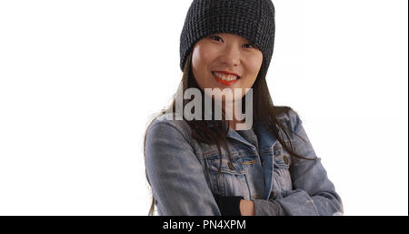 Freddo femmina millenario indossando beanie e manopole su sfondo bianco Foto Stock