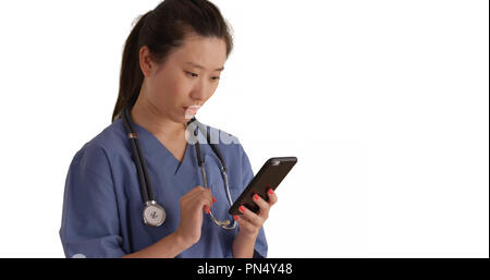 Grave medico millenario in pausa la lettura di testi con lo smartphone per copyspace Foto Stock