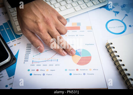 Preparazione del report grafici e diagrammi. Report di Business una pila di documenti e il computer portatile sul tavolo Foto Stock