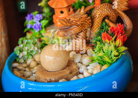 Mini fontana per giardino decorazione con dragon splash e getto di acqua per la pietra di rolling ball. Messa a fuoco selettiva Foto Stock