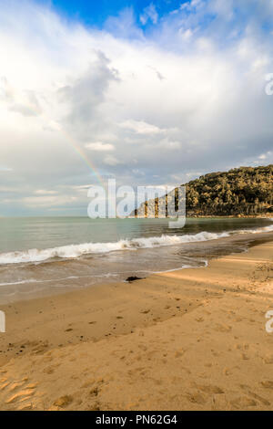 Rainbow sull'oceano e sulla spiaggia con nuvoloso cielo blu Foto Stock
